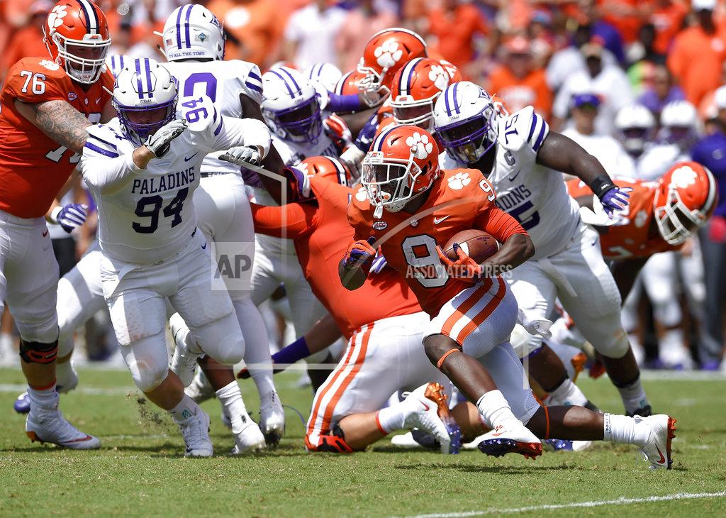 Richard Shiro Clemson's Travis Etienne rushes out of the backfield while pursued by Furman's Jaylan Reid, 75, and Jonah Tibbs during the first half of an NCAA college football game Saturday, Sept. 1, 2018, in Clemson, S.C. (AP Photo/Richard Shiro)