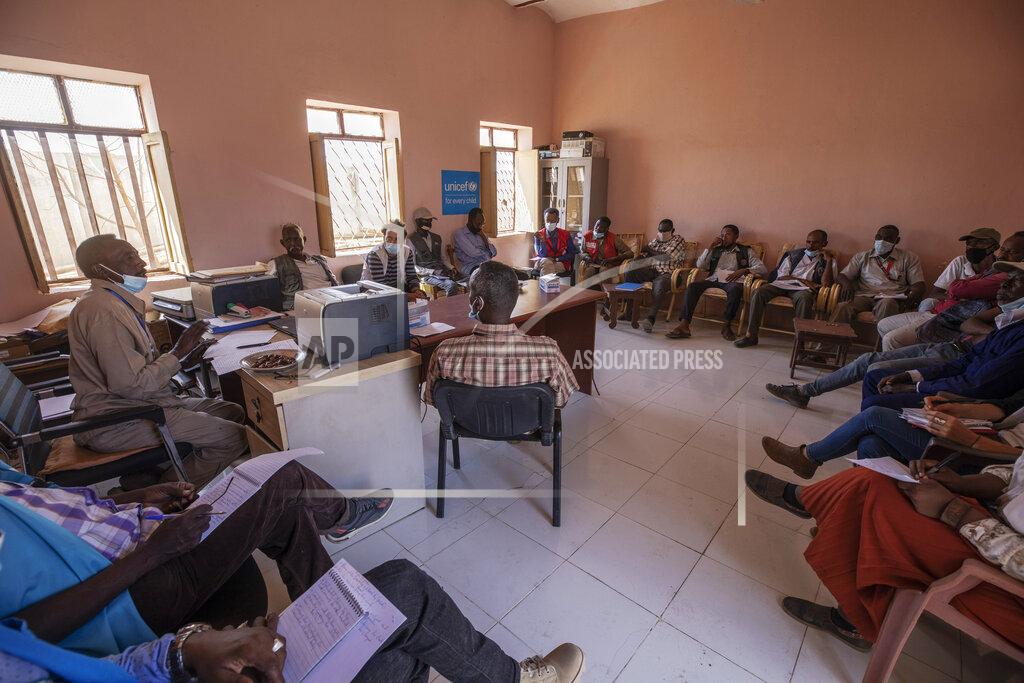 Nariman El-Mofty Surgeon and doctor-turned-refugee, Dr. Tewodros Tefera, background center, attends a weekly meeting with all non-governmental organization (NGO) representatives focusing on Tigrayan refugees, inside the Hamdayet Transition Center near the Sudan-Ethiopia border, eastern Sudan, on March 22, 2021. (AP Photo/Nariman El-Mofty)