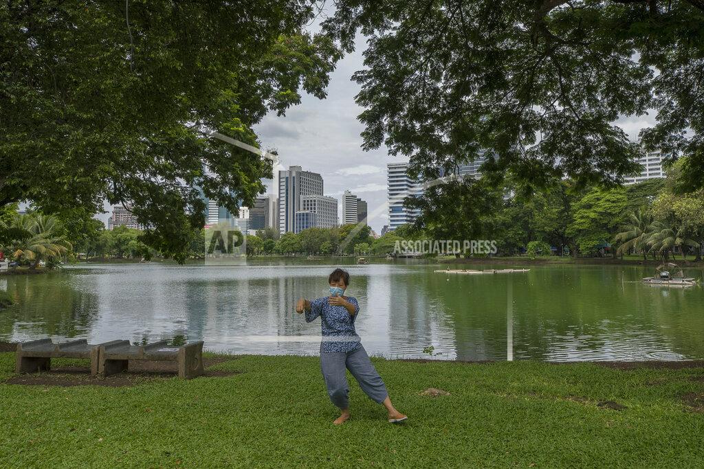 Sakchai Lalit A woman wearing a face mask to help curb the spread of the coronavirus practices Tai Chi at Lumpini park in Bangkok, Thailand, Friday, June 26, 2020. Daily life in the capital resumes to normal as the government continues to ease restrictions related to running business and activities that were imposed weeks ago to combat the spread of COVID-19. Thailand reported no local transmissions of the coronavirus in the past 4 weeks. (AP Photo/Sakchai Lalit)