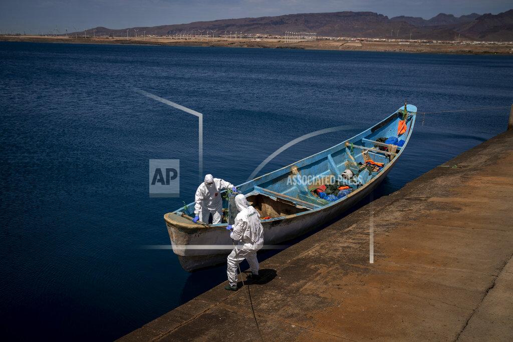 Emilio Morenatti Police officers inspect a boat where 15 Malians were found dead adrift in the Atlantic on Thursday, Aug. 20, 2020 in Gran Canaria island, Spain. The 15 lifeless men were spotted inside a boat on Aug. 19 by a Spanish plane 80 nautical miles (148 kilometers, 92 miles) from the island of Gran Canaria. (AP Photo/Emilio Morenatti)