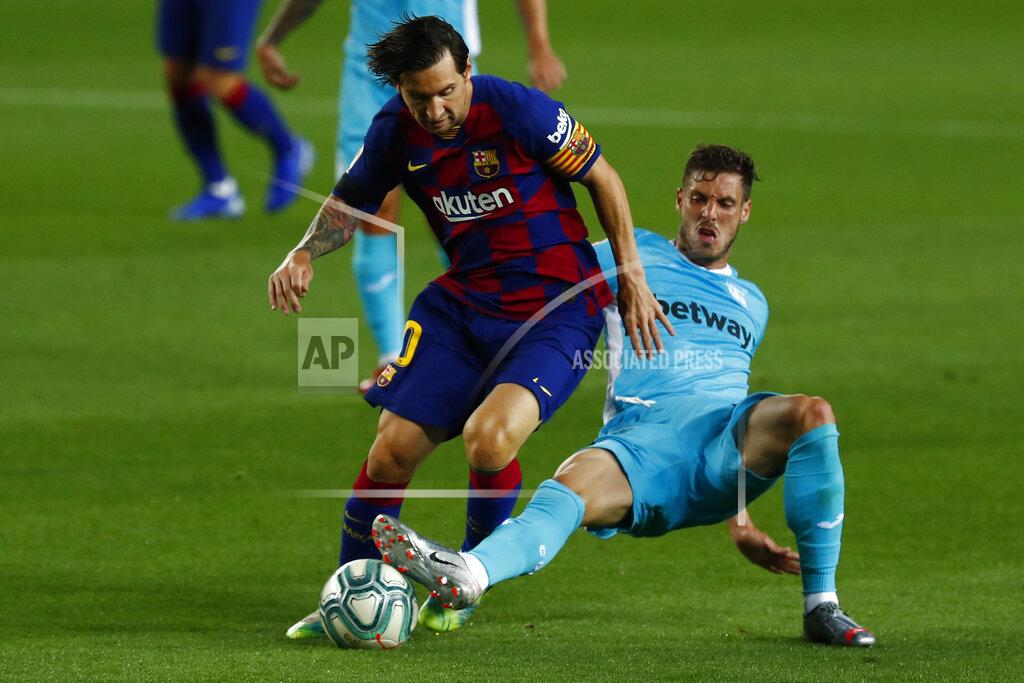 Joan Monfort FC Barcelona's Lionel Messi, left, vies for the ball with Leganes' Ruben Perez during the Spanish La Liga soccer match between FC Barcelona and Leganes at the Camp Nou stadium in Barcelona, Spain, Tuesday, June 16, 2020. (AP Photo/Joan Montfort)