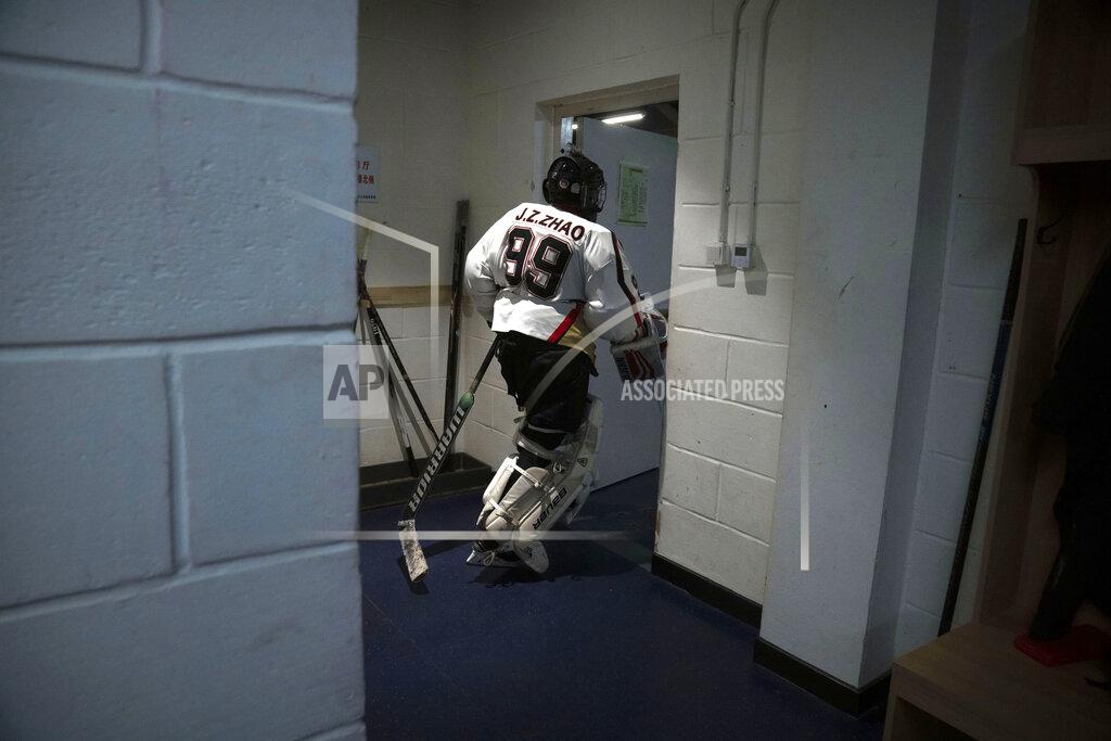 Mark Schiefelbein A members of the "1979" hockey club heads to the ice from the locker room before a hockey match at a rink in Beijing, Wednesday, Jan. 12, 2022. Spurred by enthusiasm after China was awarded the 2022 Winter Olympics, the members of a 1970s-era youth hockey team, now around 60 years old, have reunited decades later to once again take to the ice. (AP Photo/Mark Schiefelbein)