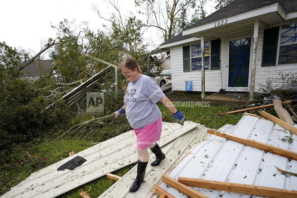 Gerald Herbert Hollie Moore walks through debris at her home on Thursday, Aug. 27, 2020, in Lake Charles, La., in the aftermath of Hurricane Laura. (AP Photo/Gerald Herbert)