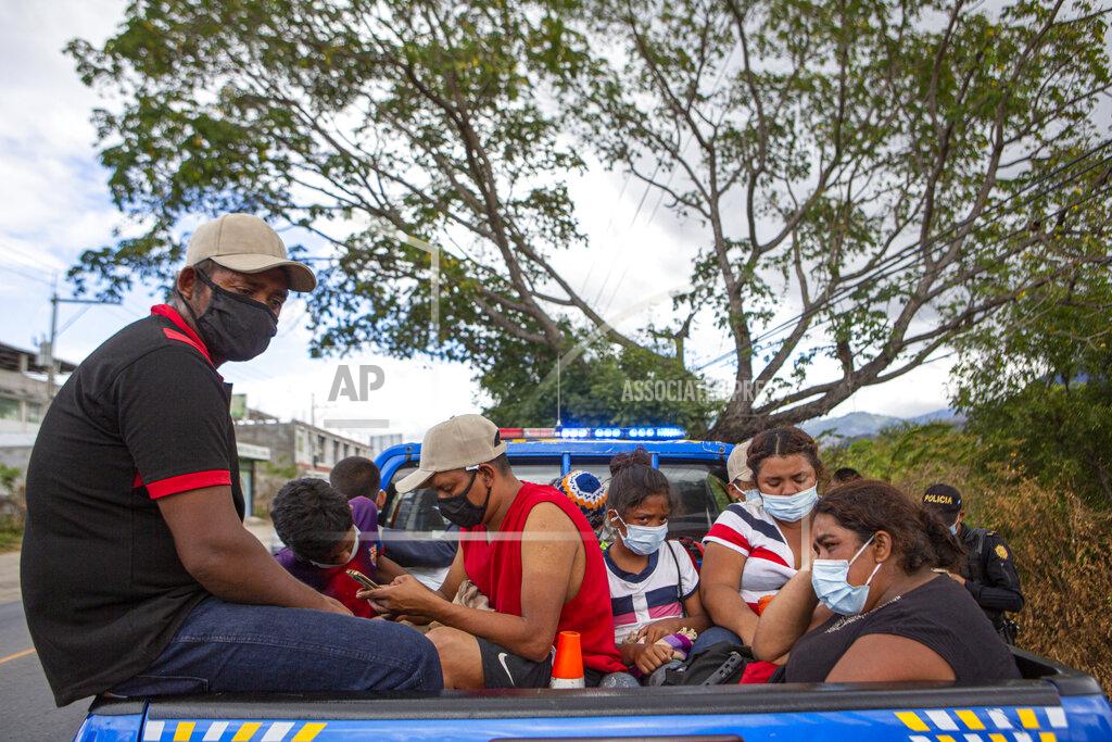 Oliver De Ros Honduran migrants sit in the bed of a police vehicle after they were detained in Chiquimula, Guatemala, Tuesday, Jan. 19, 2021. A once large caravan of Honduran migrants that pushed its way into Guatemala last week had dissipated by Tuesday in the face of Guatemalan security forces. (AP Photo/Oliver de Ros)