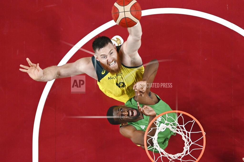 Australia's Aron Baynes, top, shoots over Nigeria's Ekpe Udoh during a men's basketball preliminary round game at the 2020 Summer Olympics, Sunday, July 25, 2021, in Saitama, Japan. (Aris Messinis/Pool Photo via AP)