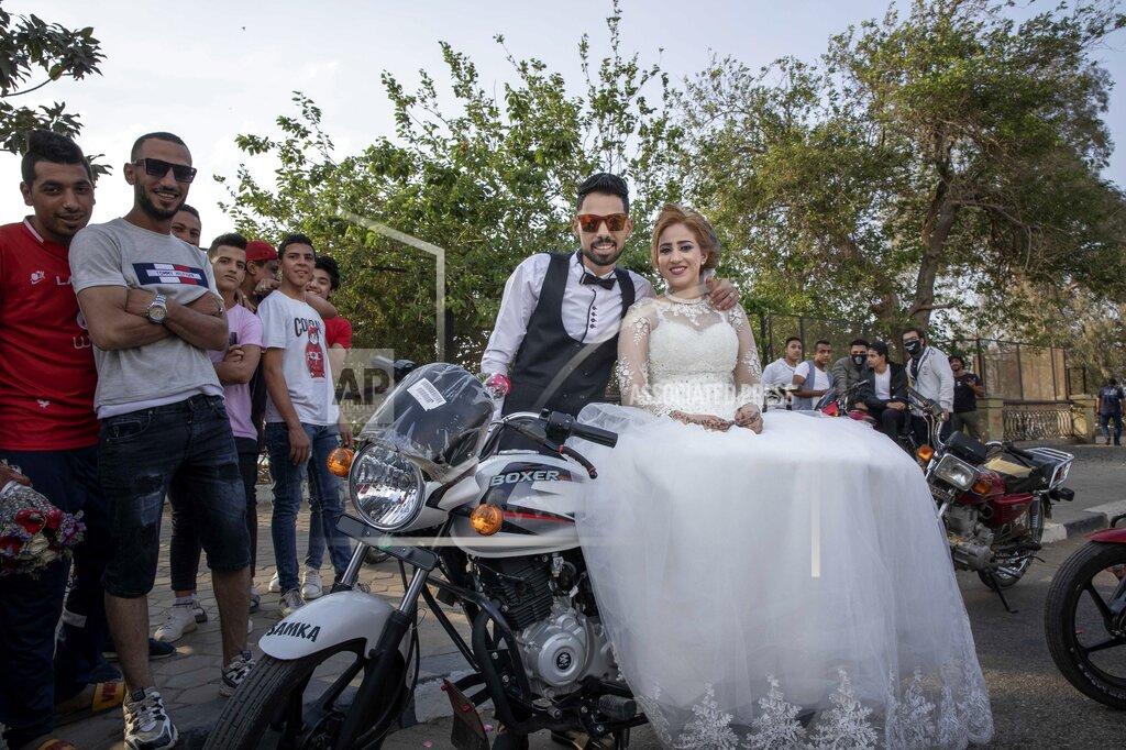 Nariman El-Mofty FILE - In this April 16, 2020 file photo, newlyweds are surrounded by their friends as they celebrate before a curfew imposed as a prevention measure against the coronavirus pandemic, in Cairo, Egypt. In a region where marriage is the cornerstone of society, couples are plowing ahead with weddings, despite the deadly risks. From the Palestinian territories to the United Arab Emirates, officials attribute a spike in coronavirus cases to traditional, large-scale weddings that flout public health restrictions. (AP Photo/Nariman El-Mofty, File)