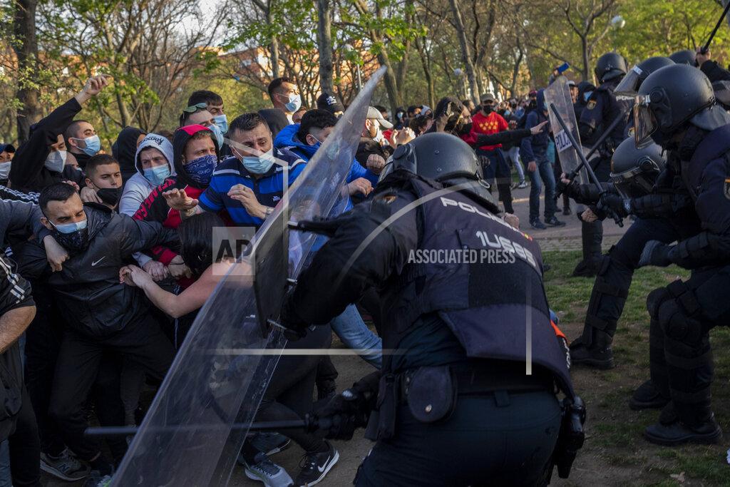 Bernat Armangue Spanish police clash with left-wing protesters in Madrid's Vallecas neighborhood in Madrid, Spain, Wednesday, April 7, 2021. Spanish police have used batons to keep protesters away from a campaign event of the far-right Vox party in Madrid. Scuffles started Wednesday when Santiago Abascal, the national leader of Vox, approached a crowd gathered to protest the party rally in Madrid's Vallecas neighborhood, a traditional left-wing bastion. Riot peace charged the bunches of protesters to keep them away from the party campaign event for upcoming regional elections. (AP Photo/Bernat Armangue)