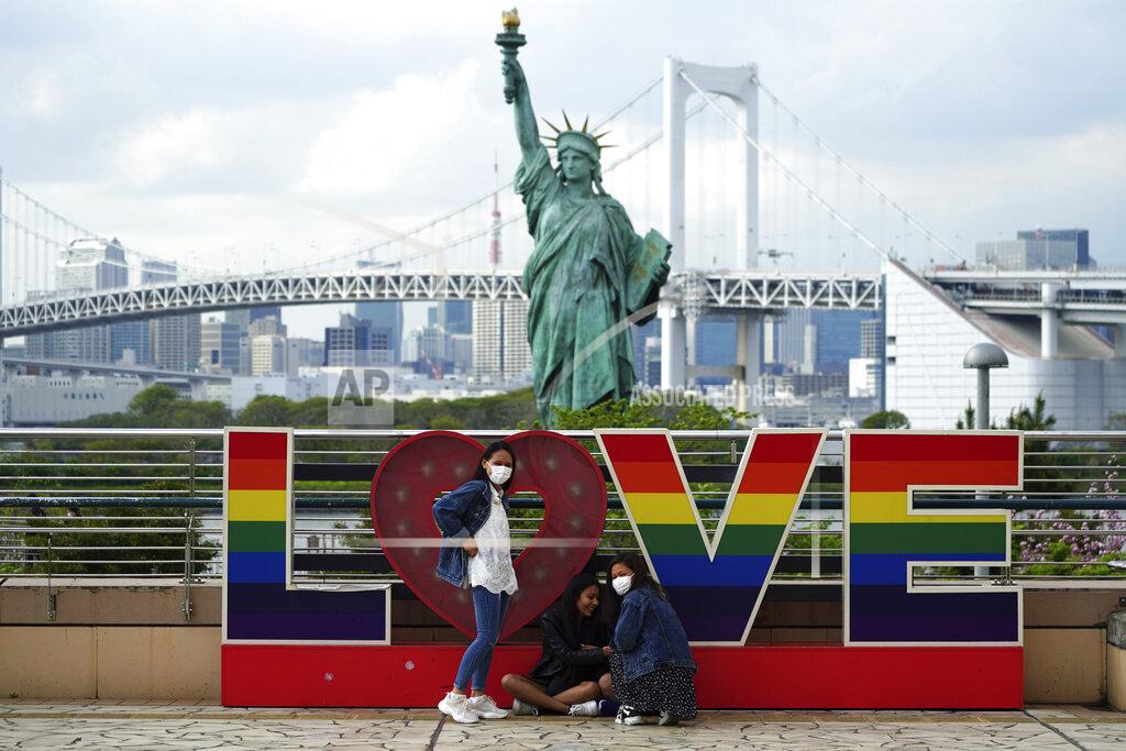 Eugene Hoshiko Visitors, wearing face masks, gather in front of the Statue of Liberty replica Thursday, April 8, 2021, in Tokyo. Tokyo has asked Japan's central government for permission to implement emergency measures to curb a surge in a rapidly spreading and more contagious coronavirus variant, just over three months before the start of the Olympics. (AP Photo/Eugene Hoshiko)