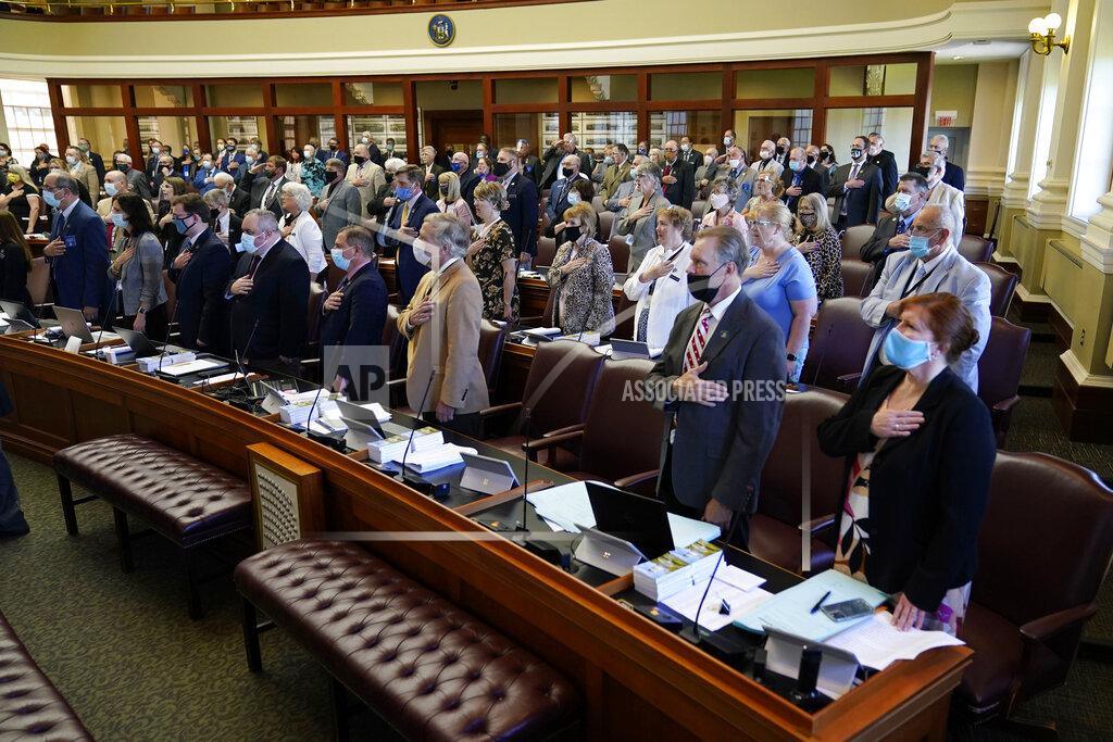 Robert F. Bukaty Rep. Joseph Fecteau, R-Augusta, stand for the National Anthem during the first legislative session in the State House since the proceedings were moved to the more spacious Augusta Civic Center, Wednesday, June 2, 2021, in Augusta, Maine. (AP Photo/Robert F. Bukaty)