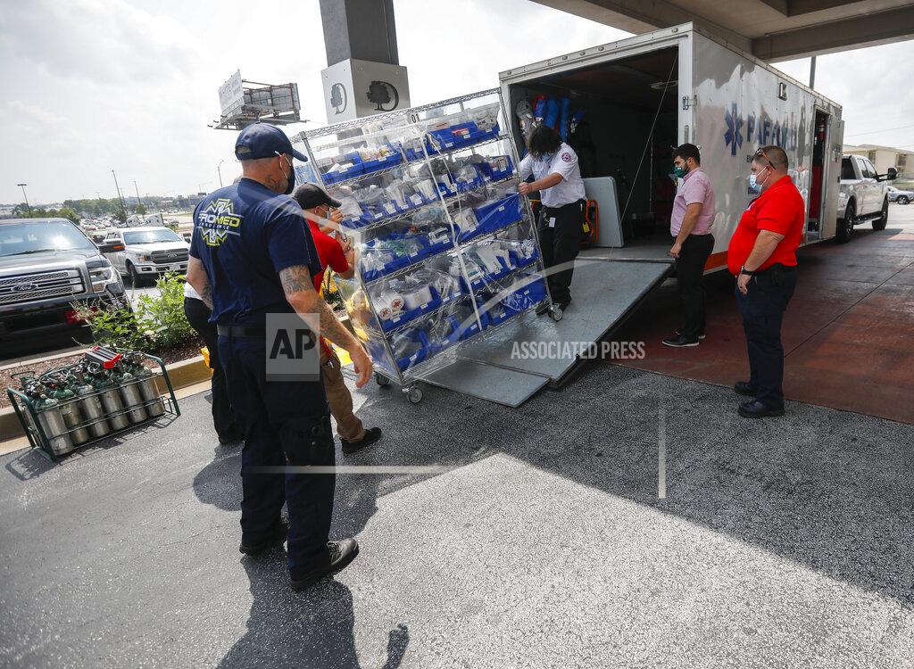 Andrew Jansen Ambulance crews unload equipment at the DoubleTree Hotel on Friday, July 23, 2021, in Springfield, Mo. The crews are part of a medical team that was sent to Springfield to help transport COVID-19 patients in the area. (Andrew Jansen/The Springfield News-Leader via AP)