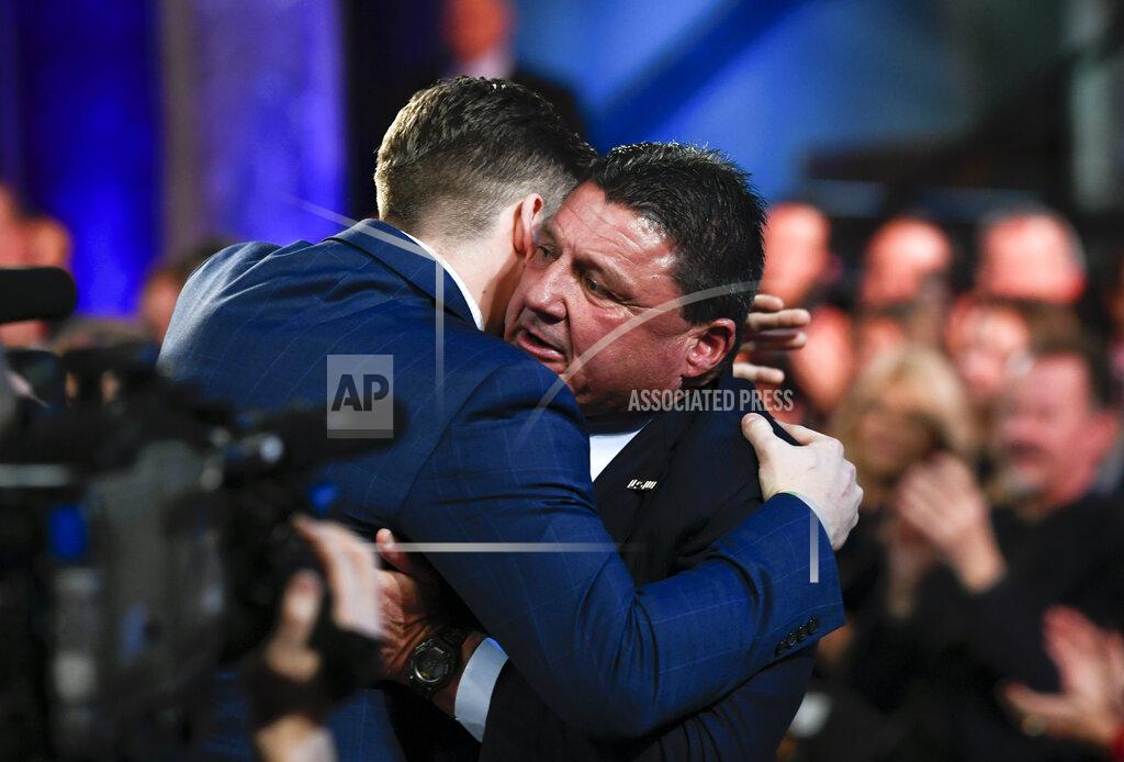 Todd Van Emst NCAA college football player, LSU quarterback Joe Burrow, left, hugs his coach Ed Orgeron after he is announced as the Heisman Trophy winner, Saturday, Dec. 14, 2019, in New York. (Todd Van Emst/Pool Photo via AP)