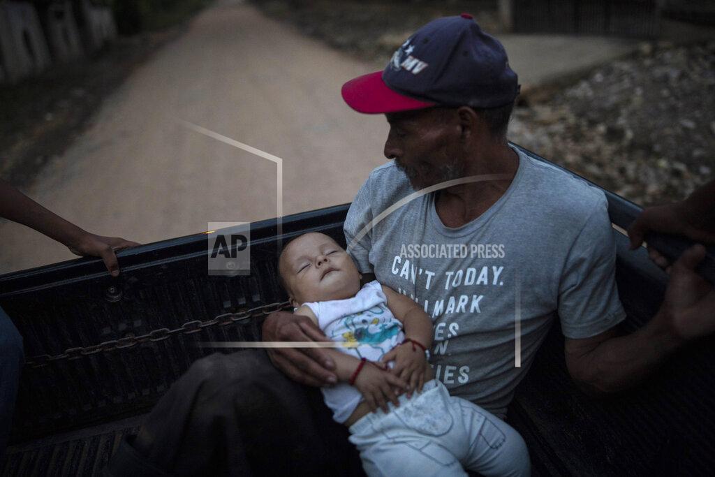 Rodrigo Abd Guillermo Alonso, 54, cradles his 6-year-old grandson Elvin, in the bed of a pickup truck as they leave the site where his home once stood, in the hillside village of La Reina, Honduras, Thursday, June 24, 2021. His home was obliterated by a mudslide triggered by Hurricanes Eta and Iota. "We feel sad because we are homeless but the important thing is that the whole family is alive,” said Alonso. (AP Photo/Rodrigo Abd)