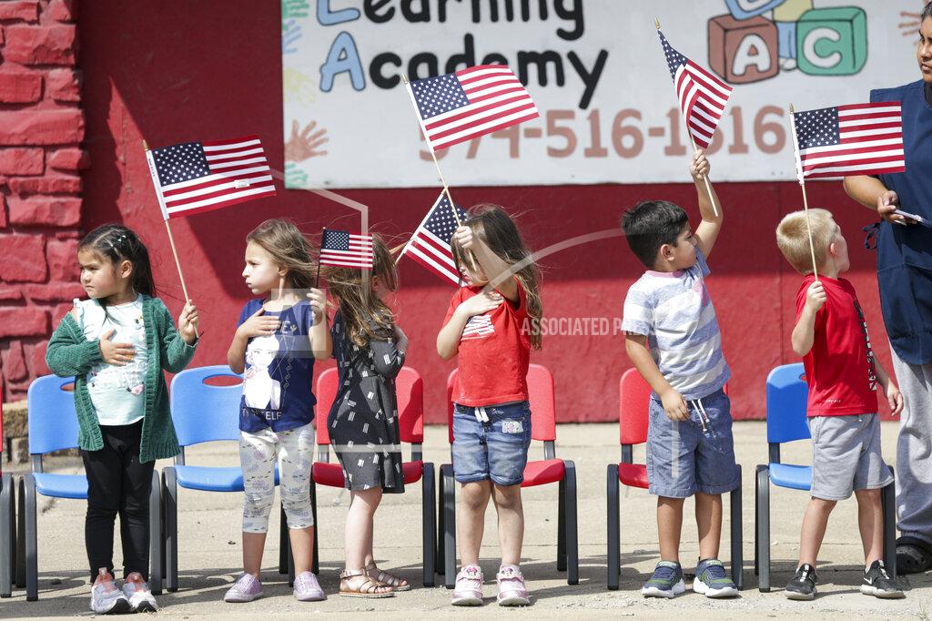 Nikos Frazier Pre-schoolers from Logansport Learning Academy save American flags in the wind during the funeral procession for Marine Cpl. Humberto Sanchez, Tuesday, Sept. 14, 2021 in Logansport, Ind. Sanchez was one of 13 U.S. service members to die in an explosion during evacuation efforts in Afghanistan. (Nikos Frazier/Journal & Courier via AP)