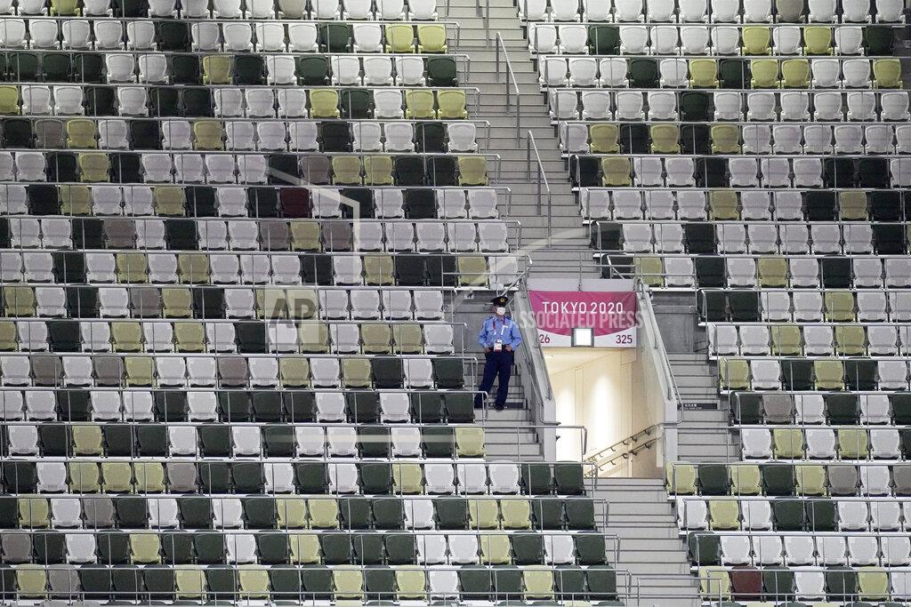 David J. Phillip A security officer looks out over an empty stadium before the opening ceremony in the Olympic Stadium at the 2020 Summer Olympics, Friday, July 23, 2021, in Tokyo, Japan. (AP Photo/David J. Phillip)