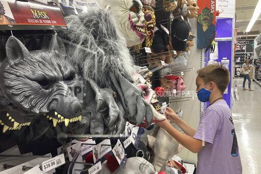 A young customer looks at a Halloween mask at a Party City store, Wednesday, Oct. 6, 2021, in Miami. Americans continued to spend at a solid clip in September despite rising prices and snarled global supply chains that are limiting the flow of goods. Retail sales rose a seasonally adjusted 0.7% in September from the month before, the U.S. Commerce Department said Friday, Oct. 15. (AP Photo/Marta Lavandier)