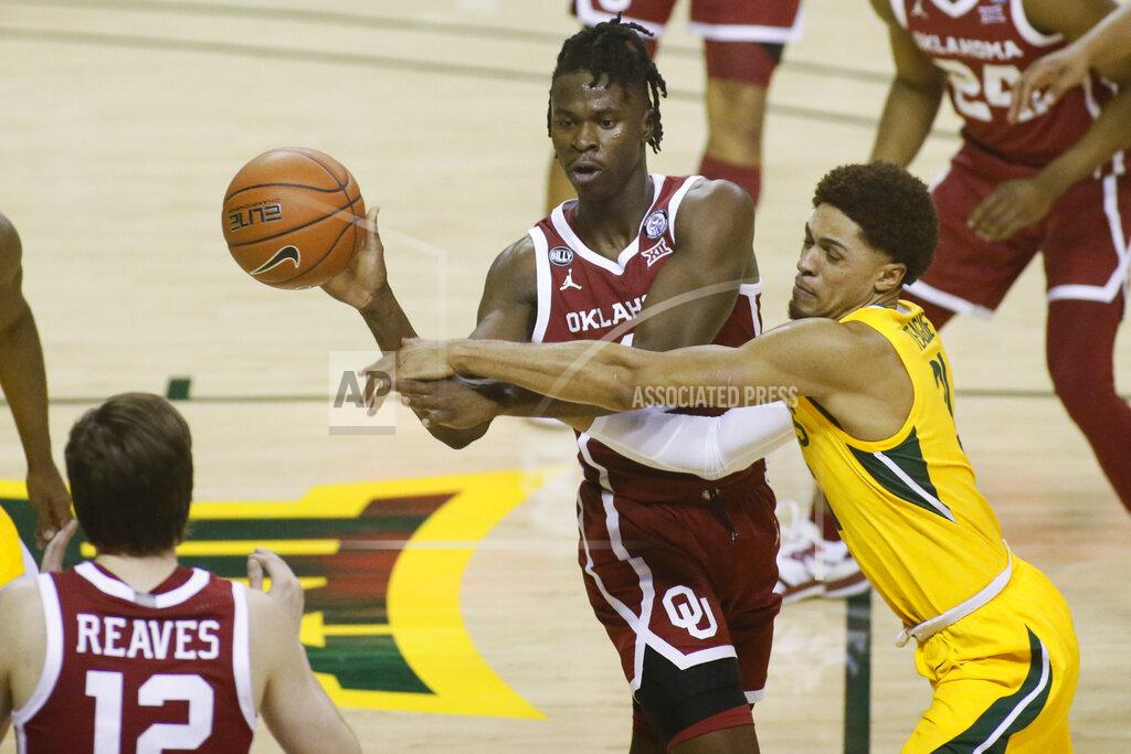 Ray Carlin Oklahoma forward Victor Iwuakor, left, passes the ball as he is defended by Baylor guard MaCio Teague, right, during the first half of an NCAA college basketball game on Wednesday, Jan. 6, 2021, in Waco, Texas. (AP Photo/Ray Carlin)