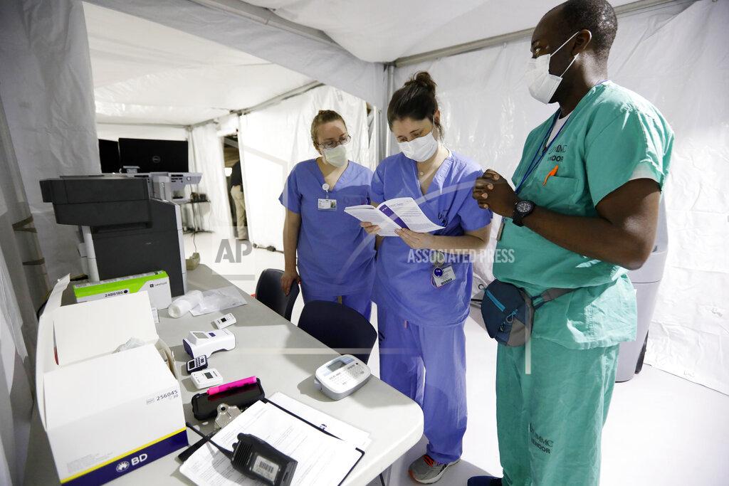 Rogelio V. Solis Medical professionals review procedure at the University of Mississippi Medical Center, while waiting for a "dry run" to begin, testing the efficiency of a new mobile field clinic built in the basement of a parking garage in Jackson, Miss., Wednesday, April 8, 2020. The facility was built in anticipation of more coronavirus cases. The clinic will have a maximum capacity of around 24 patients, with each bay spaced out and separated from the others. (AP Photo/Rogelio V. Solis)