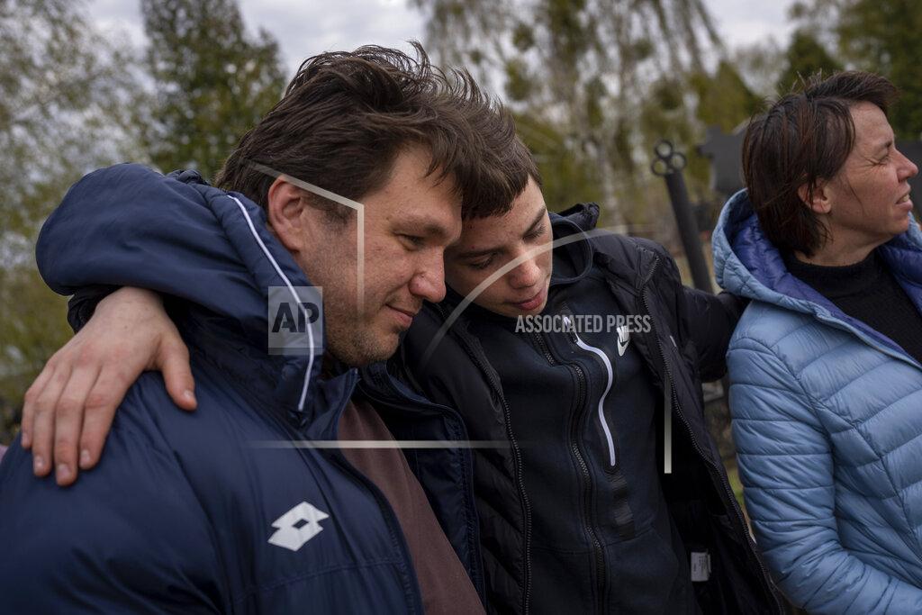 Emilio Morenatti Yura Nechyporenko, 15, hugs his uncle Andriy Nechyporenko next to the grave of his father Ruslan Nechyporenko at the cemetery in Bucha, on the outskirts of Kyiv, Ukraine, on Monday, April 25, 2022. The teen survived an execution attempt by Russian soldiers while his father was killed, and now his family seeks justice. (AP Photo/Emilio Morenatti)