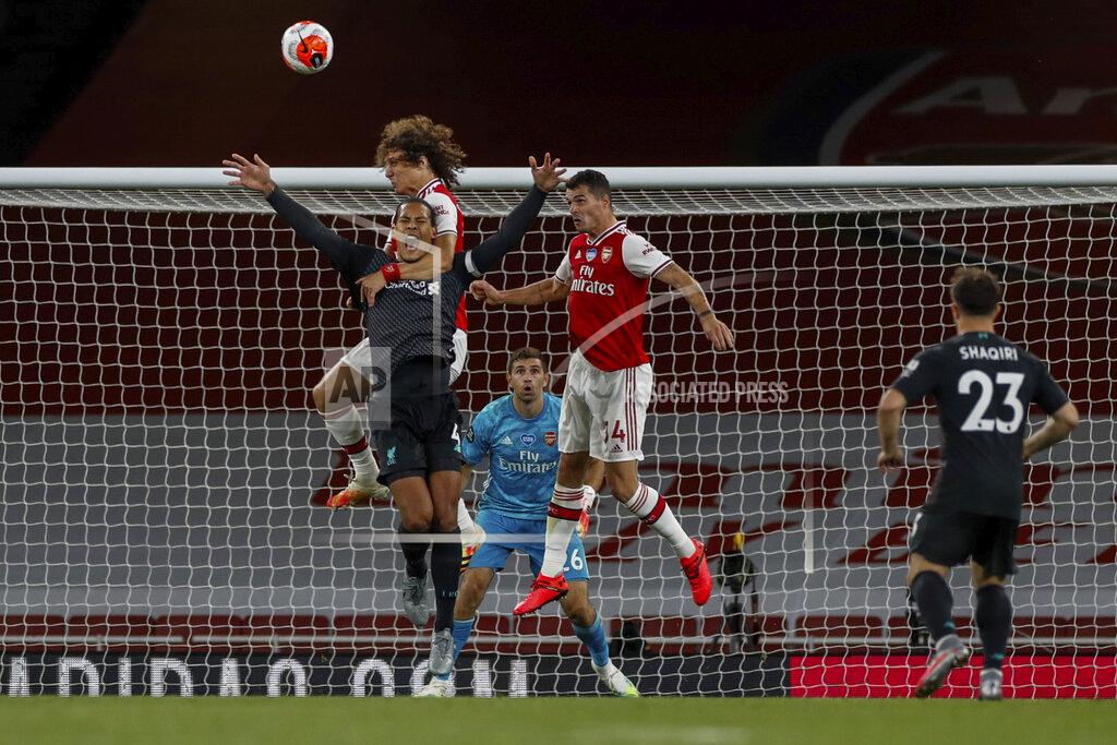 Paul Childs Arsenal's David Luiz grabs Liverpool's Virgil van Dijk, foreground and left, during the English Premier League soccer match between Arsenal and Liverpool at the Emirates Stadium in London, England, Wednesday, July 15, 2020. (Paul Childs/Pool via AP)