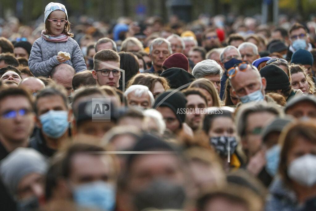 Laszlo Balogh A child sits on a man's shoulders as Hungarian opposition supporters listen to a speech by Prime Minister candidate Peter Marki-Zay during celebration the 65th anniversary of the 1956 Hungarian revolution, in Budapest, Hungary, Saturday, Oct. 23, 2021. Earlier thousands of supporters of Prime Minister Viktor Orban, who delivered a speech marking the 65th anniversary of the 1956 Hungarian revolution, marched to demonstrate loyalty to his right-wing government. (AP Photo/Laszlo Balogh)