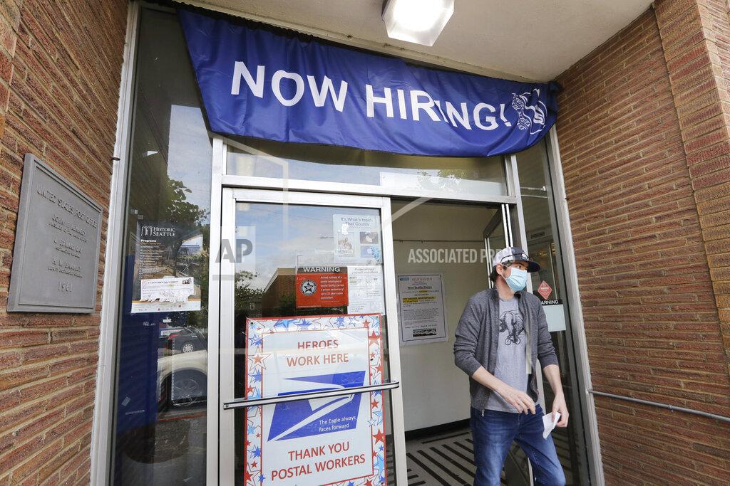 Elaine Thompson In this photo taken Thursday, June 4, 2020, a customer walks out of a U.S. Post Office branch and under a banner advertising a job opening, in Seattle. The U.S. unemployment rate fell to 13.3% in May, and 2.5 million jobs were added — a surprisingly positive reading in the midst of a recession that has paralyzed the economy and depressed the job market in the wake of the viral pandemic (AP Photo/Elaine Thompson)