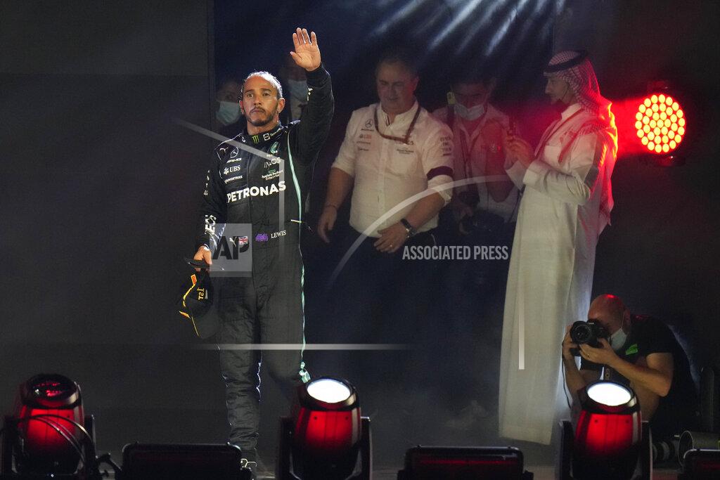 Hassan Ammar Mercedes driver Lewis Hamilton of Britain waves from the podium after winning the Formula One Saudi Arabian Grand Prix in Jiddah, Sunday, Dec. 5, 2021. (AP Photo/Hassan Ammar)