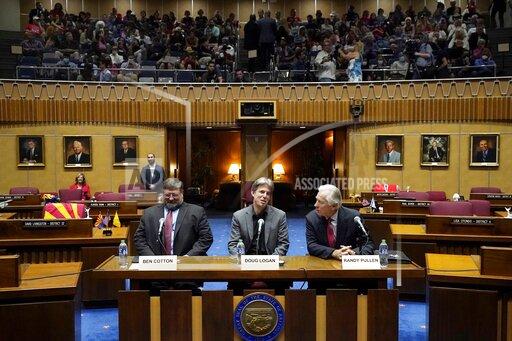 Cyber Ninjas CEO Doug Logan, center, is flanked by Ben Cotton, left, founder of digital security firm CyFIR, and Randy Pullen, right, the former Chairman of the Arizona Republican Party, prior to the Arizona Senate Republicans hearing review of the 2020 presidential election results in Maricopa County at the Arizona Capitol Friday, Sept. 24, 2021, in Phoenix. (AP Photo/Ross D. Franklin)