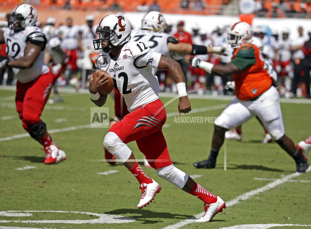 FILE - In this Oct. 11, 2014 file photo, Cincinnati quarterback Jarred Evans (12) runs in the second half of an NCAA college football game against Miami in Miami Gardens, Fla. Evans, one 195 Americans who were flown out of the city of Wuhan Wednesday on a plane chartered by the U.S. government, says he's wearing a mask and gloves and taking special precautions while staying at March Air Reserve Base in Riverside, Calif. (AP Photo/Lynne Sladky, File)