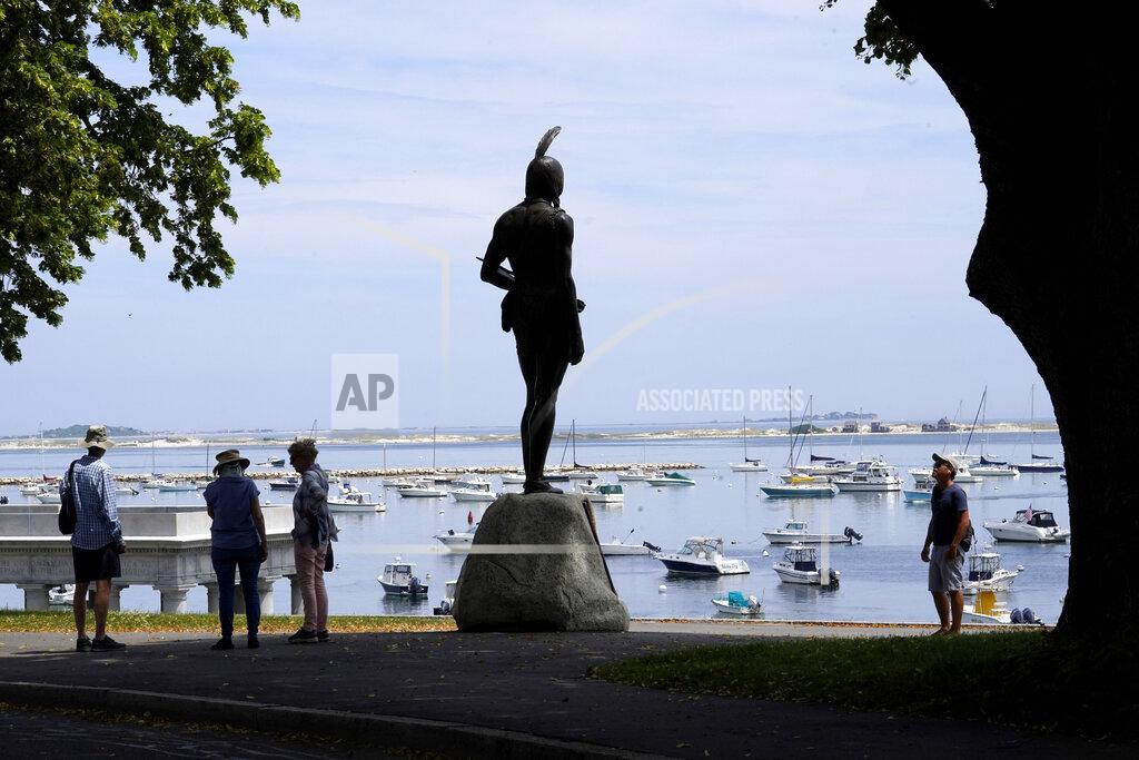 Steven Senne Visitors stand near a 1921 statue of the Wampanoag leader Massasoit, center, Wednesday, June 9, 2021, on Cole's Hill, in Plymouth, Mass. (AP Photo/Steven Senne)