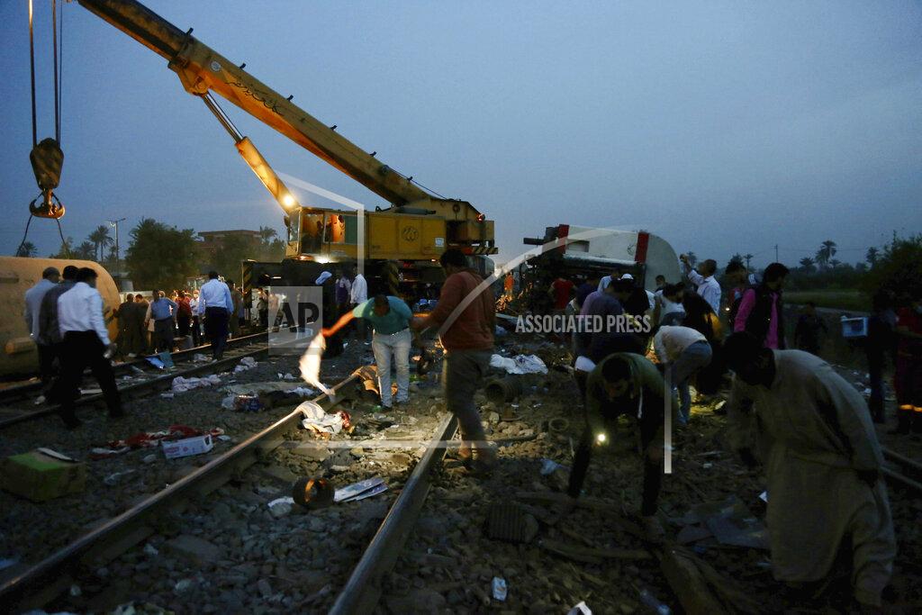 Fadel Dawood People search for belongings in the aftermath of a passenger train that derailed injuring around 100 people, near Banha, Qalyubia province, Egypt, Sunday, April 18, 2021. The train was travelling to the Nile Delta city of Mansoura from the Egyptian capital, the statement said. (AP Photo/Fadel Dawood)