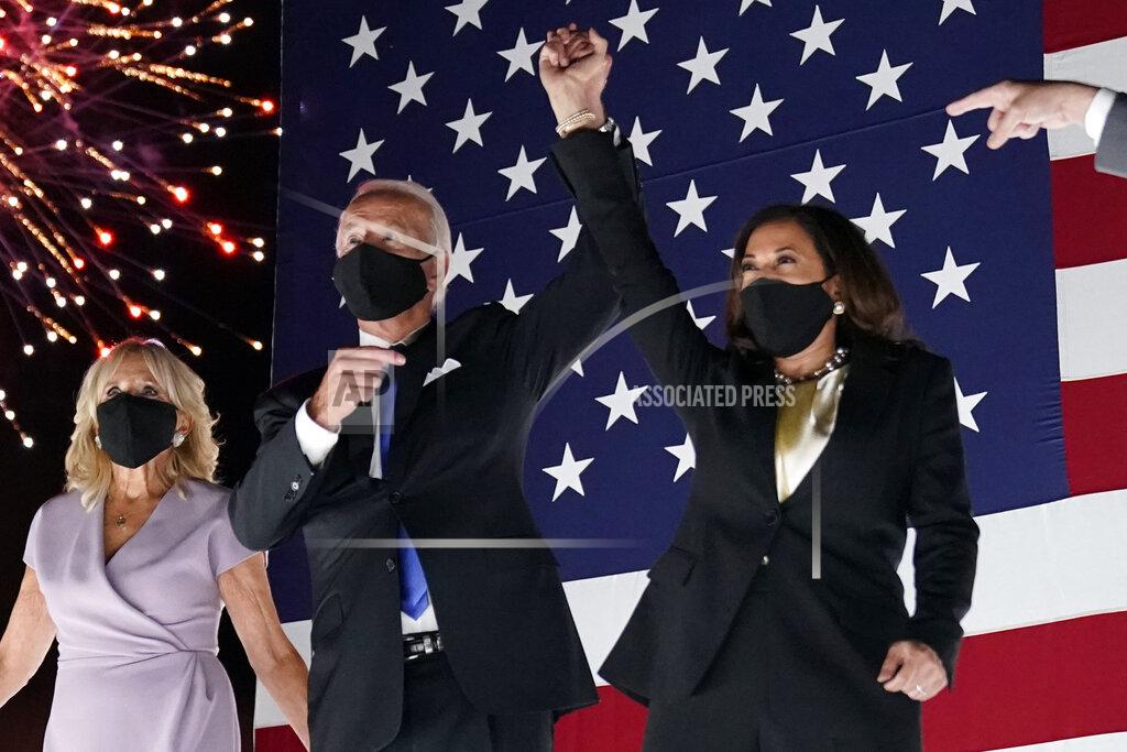 Democratic presidential candidate former Vice President Joe Biden raises his arm with his running mate Sen. Kamala Harris, D-Calif., during the fourth day of the Democratic National Convention, Thursday, Aug. 20, 2020, at the Chase Center in Wilmington, Del. Jill Biden is at left. (AP Photo/Andrew Harnik)