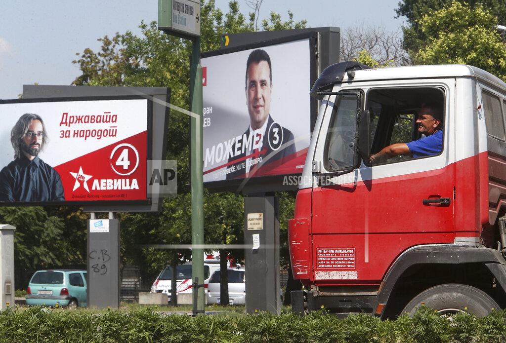 Boris Grdanoski A man drives a truck past electoral posters of the leader of the ruling Social Democrats Zoran Zaev, right, and a poster of the leader of the Leftist party Dimitar Apasiev, in a street in Skopje, North Macedonia on Saturday, July 11, 2020. North Macedonia holds its first parliamentary election under its new country name this week, with voters heading to the polls during an alarming spike of coronavirus cases in the small Balkan nation. (AP Photo/Boris Grdanoski)