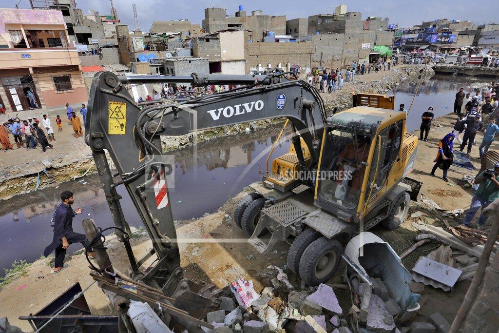Fareed Khan Local authorities use heavy machinery to demolish illegal construction alongside a drainage canal which saw flooding last week due to heavy monsoon rains, in Karachi, Pakistan, Wednesday, Sept. 2, 2020. Flash floods triggered by heavy rains killed some people and damaged scores of houses in Pakistan's scenic northwestern Swat Valley, a spokesman said Wednesday, as rescuers assisted residents in the port city of Karachi where last week's rains wreaked havoc that killed dozens. (AP Photo/Fareed Khan)