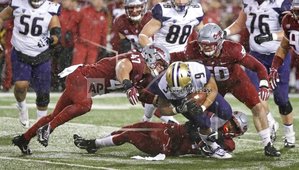 Ted S. Warren Washington running back Myles Gaskin (9) rushes as Washington State linebacker Peyton Pelluer, left, and Washington State linebacker Karson Block, right, move in for the tackle during the first half of an NCAA college football game, Friday, Nov. 23, 2018, in Pullman, Wash. (AP Photo/Ted S. Warren)