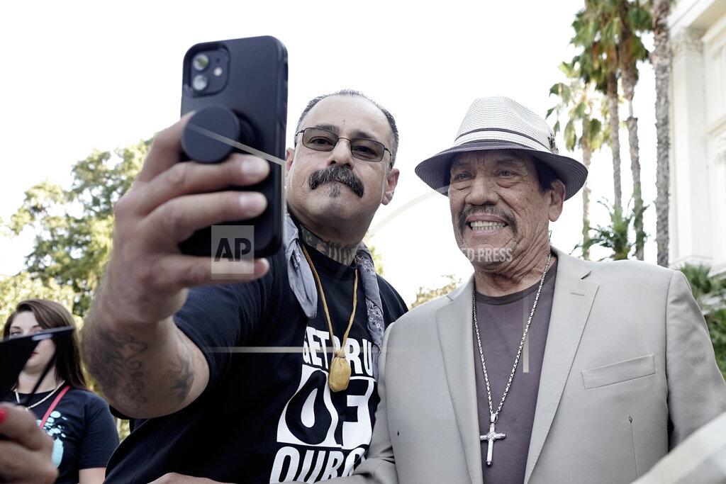 Rich Pedroncelli Albert Roman Jr., left, takes a photo with actor Danny Trejo who spoke at the recovery rally about overcoming drug addiction, during a stop of the 2022 Mobile Recovery National Bus tour at the Capitol in Sacramento, Calif. Sept. 7, 2022. Across the country, people in recovery and relatives of those killed by opioid overdoses are pressing for roles in determining how billions in opioid settlement money will be used. That push is one of the missions of the monthlong nationwide bus tour. Through counseling and a desire to have a better life Roman Jr. has worked to overcome a 30 year drug and alcohol addiction. (AP Photo/Rich Pedroncelli)