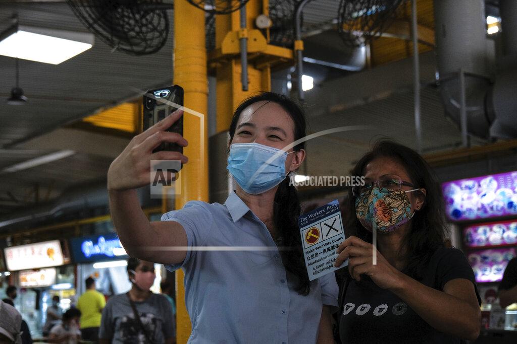 Ee Ming Toh Workers' Party candidate Nicole Seah takes a selfie with a female supporter at Bedok South market during the final day of the election campaign Wednesday, July 8, 2020, in Singapore. Singaporeans go to the polls on July 10 in Southeast Asia's first election since the coronavirus pandemic began, with the health crisis and an economic recession expected to bolster Prime Minister Lee Hsien Loong's party and extend its unbroken rule. (AP Photo/Ee Ming Toh)