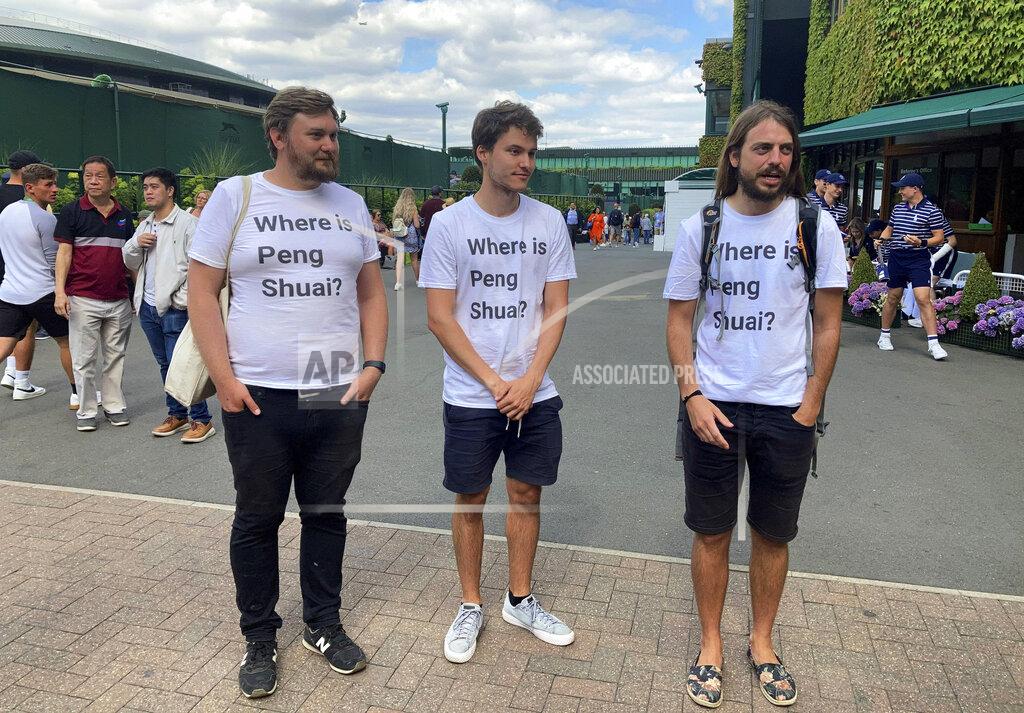 Rebecca Speare-Cole From left Protesters Will Hoyles, 39, Caleb Compton, 27, and Jason Leith, 34, who all work for Free Tibet pose for the media in T-shirts reading "Where is Peng Shuai", at the Wimbledon Tennis tournament in London, Monday, July 4, 2022. Four activists wearing “Where is Peng Shuai?” T-shirts were stopped by security at Wimbledon on Monday and had their bags searched. (Rebecca Speare-Cole/PA via AP)