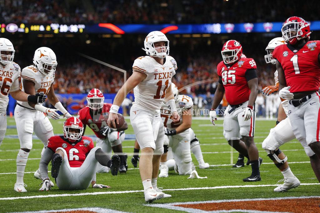 Gerald Herbert Texas quarterback Sam Ehlinger (11) reacts after scoring a touchdown, between Georgia linebacker Natrez Patrick (6), defensive lineman Devonte Wyatt (95) and linebacker Brenton Cox (1) during the first half of the Sugar Bowl NCAA college football game in New Orleans, Tuesday, Jan. 1, 2019. (AP Photo/Gerald Herbert)