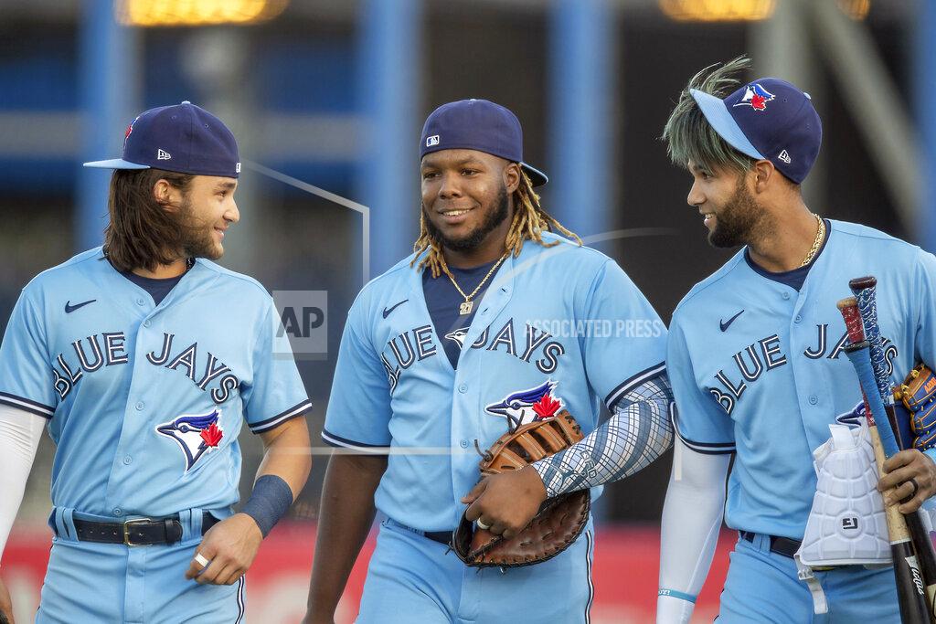 Mike Carlson Toronto Blue Jays' Bo Bichette, Vladimir Guerrero Jr. and Lourdes Gurriel Jr., from left, walk onto the field for the team's baseball game against the Boston Red Sox on Tuesday, May 18, 2021, in Dunedin, Fla. (AP Photo/Mike Carlson)