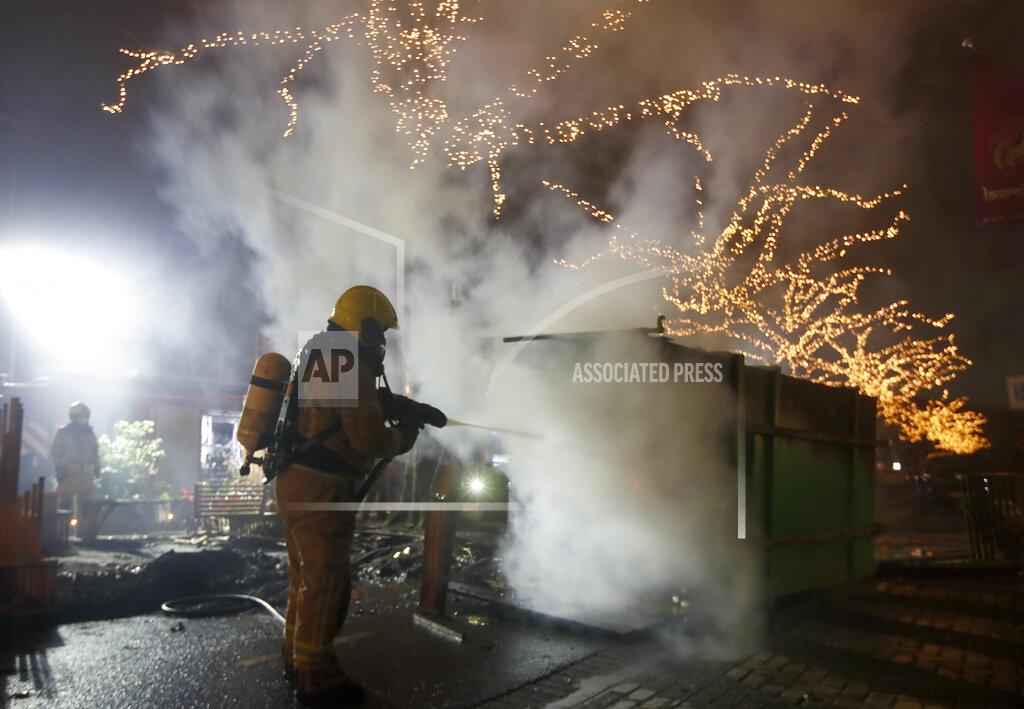 Peter Dejong A firefighter extinguishes a container that was set alight during protests against a nation-wide curfew in Rotterdam, Netherlands, Monday, Jan. 25, 2021. The Netherlands Saturday entered its toughest phase of anti-coronavirus restrictions to date, imposing a nationwide night-time curfew from 9 p.m. until 4:30 a.m. in a bid to control the COVID-19 infection rate. (AP Photo/Peter Dejong)