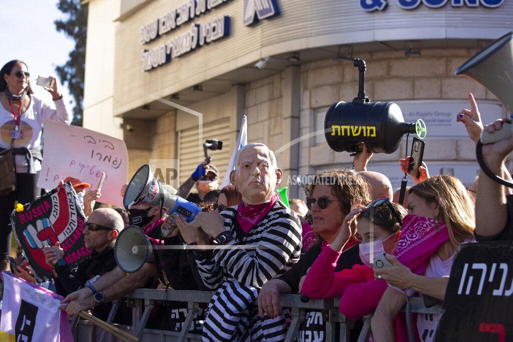 Maya Alleruzzo Protesters, including one wearing a mask depicting Israeli Prime Minister Benjamin Netanyahu, gather outside the District Court during a hearing in his corruption trial, in Jerusalem, Monday, Feb. 8, 2021. Netanyahu has pleaded not guilty as his trial on corruption charges resumes in a Jerusalem courtroom just weeks before national elections in which he hopes to extend his 12-year rule. (AP Photo/Maya Alleruzzo)