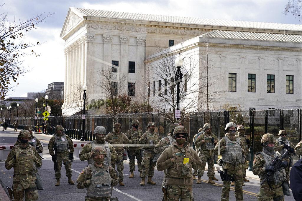 John Minchillo FILE - In this Wednesday, Jan. 20, 2021 file photo, members of the National Guard stand at a road block near the Supreme Court ahead of President-elect Joe Biden's inauguration ceremony in Washington. On Friday, Jan. 29, 2021, The Associated Press reported on stories circulating online incorrectly asserting Donald Trump invited National Guard members to stay at Trump Hotel in Washington so they don’t have to sleep in a cold parking garage. A spokesperson with the National Guard Bureau told The Associated Press they had not received any offers to stay at Trump International Hotel Washington, D.C., the former president’s hotel. (AP Photo/John Minchillo)