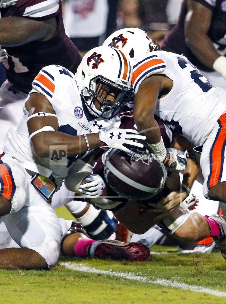 Rogelio V. Solis Auburn defensive backs Daniel Thomas, left, and Jeremiah Dinson, fail from keeping Mississippi State quarterback Nick Fitzgerald, underneath, from scoring on a one-yard dive into the end zone during the first half of their NCAA college football game in Starkville, Miss., Saturday, Oct. 6 2018. (AP Photo/Rogelio V. Solis)