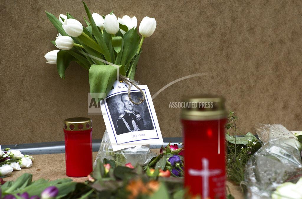 Markus Schreiber A portrait of Britain's Prince Philip is placed with flowers and candles in front of the British embassy in Berlin, Germany, Saturday, April 10, 2021. Britain's Prince Philip, husband of Queen Elizabeth II, who spent more than seven decades supporting his wife in a role that mostly defined his life, died on Friday. (AP Photo/Markus Schreiber)