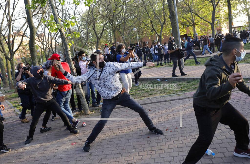 Bernat Armangue Protesters throw stones at far-right Vox supporters during a party rally in Madrid's Vallecas neigborhood, a traditional left-wing bastion, Spain, Wednesday, April 7, 2021. Scuffles started when the national leader of Vox, Santiago Abascal, approached a crowd which had gathered to protest the party rally. Riot peace charged the bunches of protesters to keep them away from Abascal and other members of his party campaigning for upcoming regional elections in the area including Spain's capital. (AP Photo/Bernat Armangue)