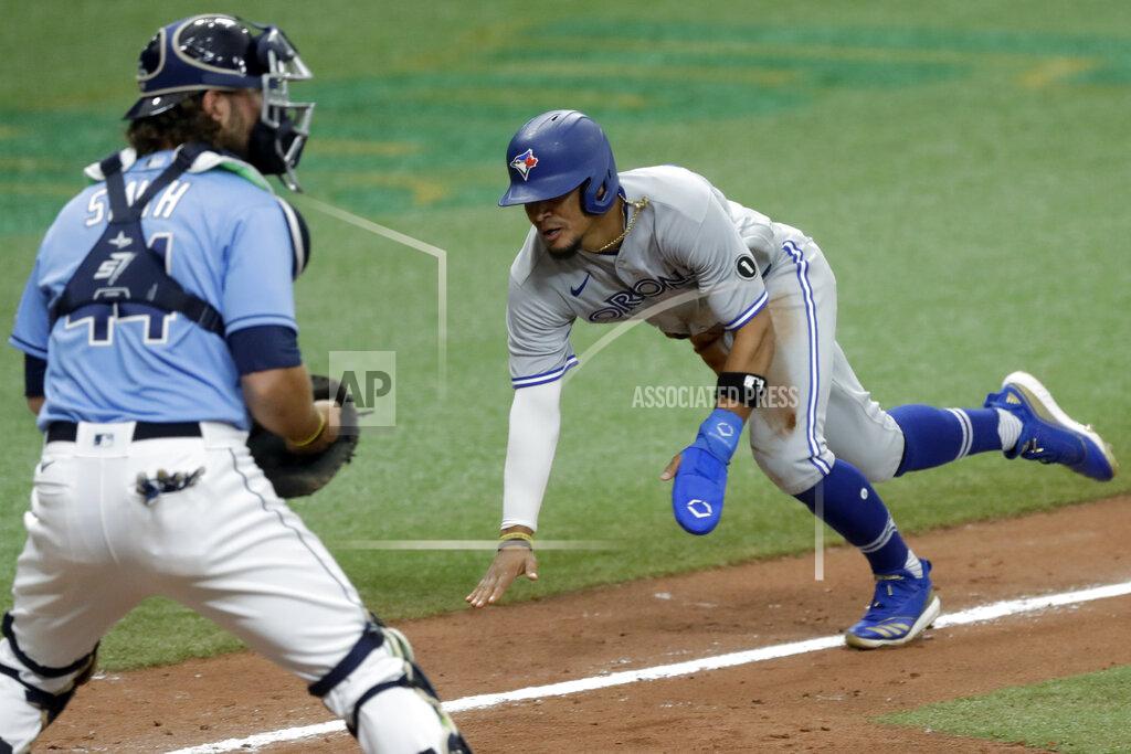 Chris O'meara Toronto Blue Jays' Santiago Espinal scores in front of Tampa Bay Rays catcher Kevan Smith (44) on a sacrifice fly by Lourdes Gurriel Jr. during the 10th inning of a baseball game Sunday, July 26, 2020, in St. Petersburg, Fla. (AP Photo/Chris O'Meara)