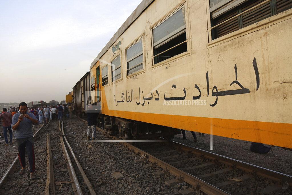 Fadel Dawood People take photos with their mobile phones at the site of a passenger train that derailed injuring some 100 people, near Banha, Qalyubia province, Egypt, Sunday, April 18, 2021. At least eight train wagons ran off the railway, the provincial governor's office said in a statement. (AP Photo/Fadel Dawood)