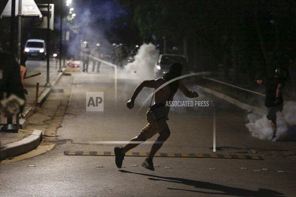 Giannis Papanikos A protester runs during a protest at the University of Thessaloniki in northern Greece, Thursday, May 26, 2022. Earlier Thursday, the protesters faced off with police inside the city's main university campus, where unrest has been bubbling for weeks over a left-wing squat that was closed down. (AP Photo/Giannis Papanikos)
