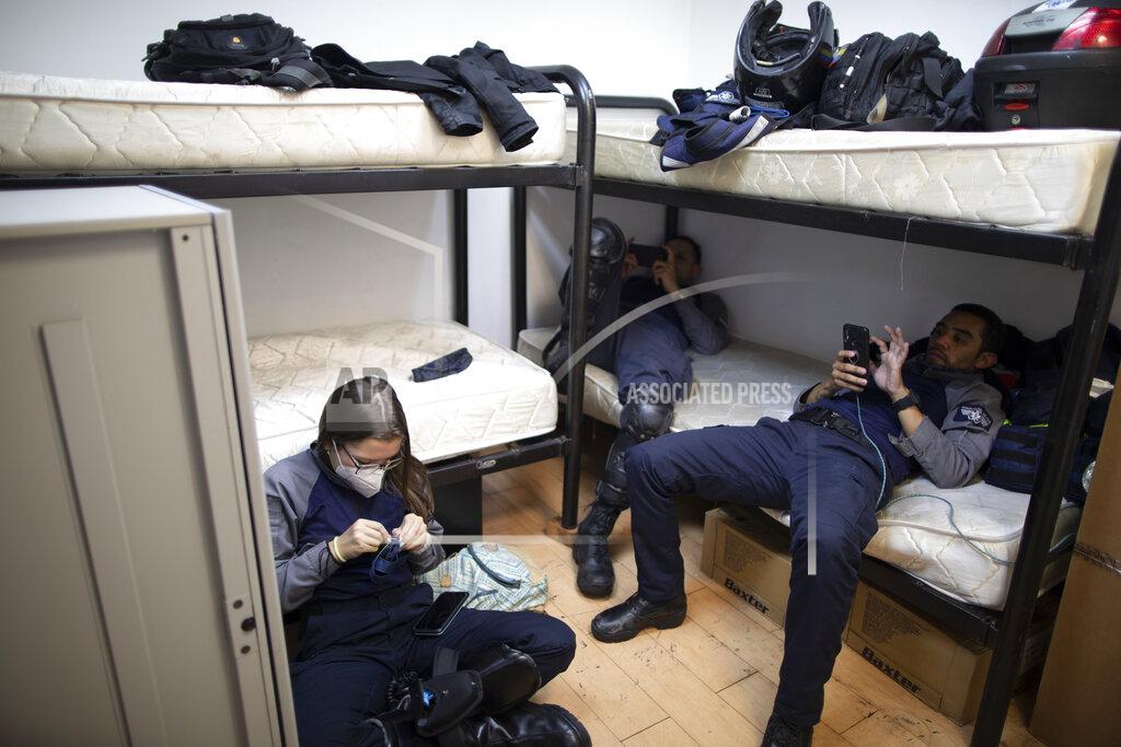 Ariana Cubillos Wearing masks as a precaution against the new coronavirus, Angels of the Road volunteer paramedics Laura Lara, from left, Alexander Barreto and Bran Cabello, relax in the only room they have at their operations base in Caracas, Venezuela, Monday, Feb. 8, 2021. Their operations base is located in a rented office space in a national newspaper building that no longer prints a paper edition. (AP Photo/Ariana Cubillos)