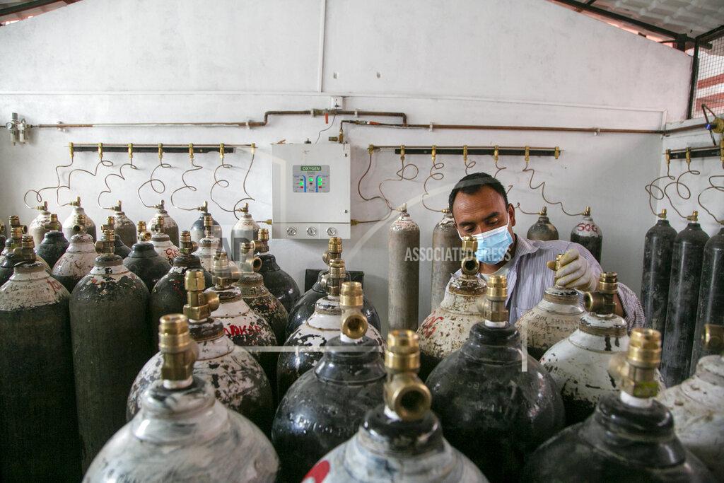Niranjan Shrestha Staff member of a government run hospital checks to refill the empty oxygen cylinders in Kathmandu, Nepal, Friday, May 7, 2021. Across the border from a devastating surge in India, doctors in Nepal warned Friday of a major crisis as daily coronavirus cases hit a record and hospitals were running out of beds and oxygen. (AP Photo/Niranjan Shrestha)